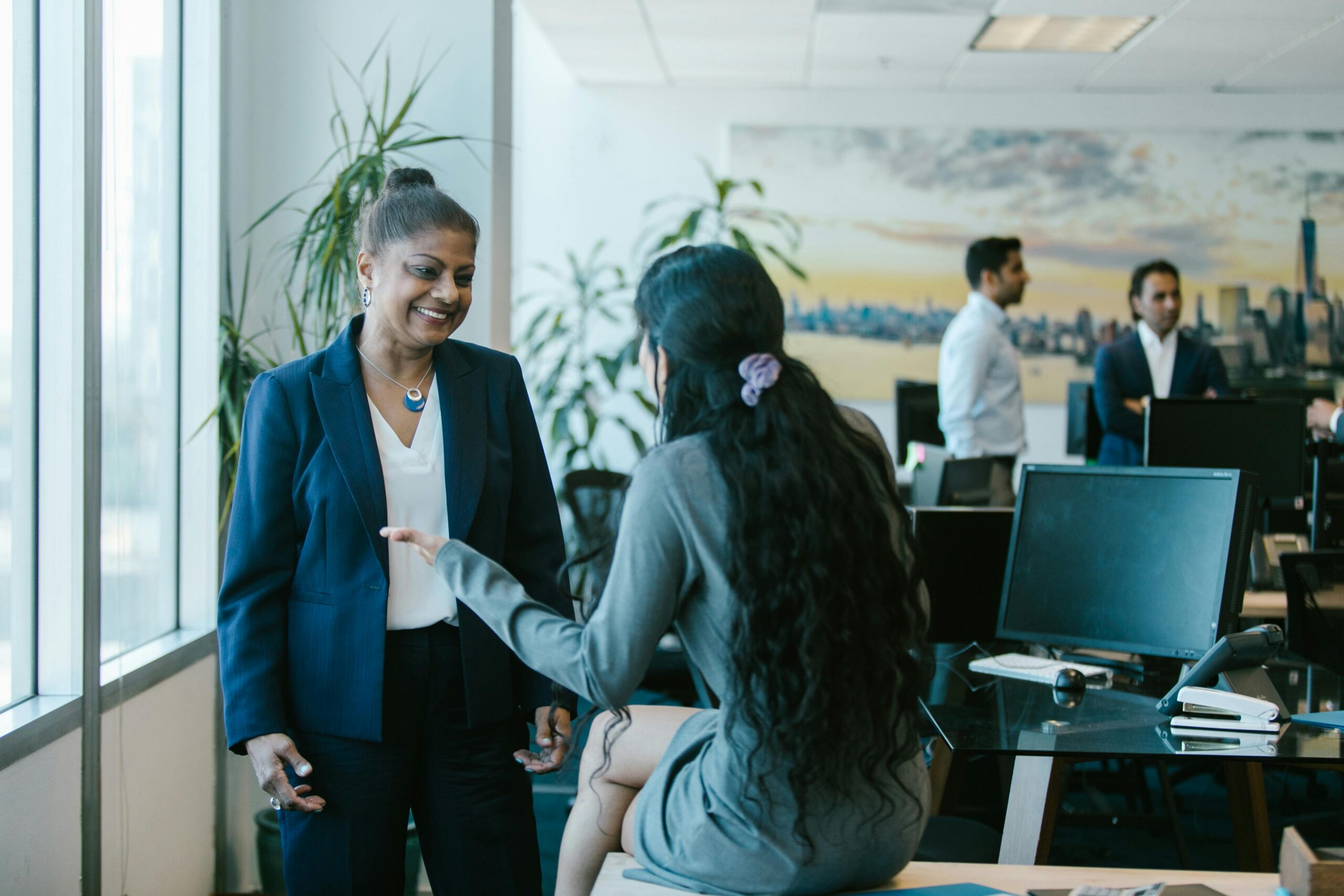Business team interacting in a modern office setting, showcasing diversity and collaboration.
